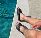 Archies arch support slides in a black style pictured being worn by a man at a pool