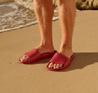 Archies arch support slides in sangria pictured being worn by a man at the beach