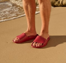 Archies arch support slides in sangria pictured being worn by a man at the beach